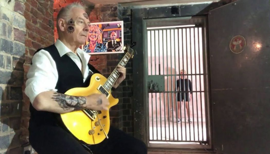 King Crimson’s Robert Fripp Performs Black Sabbath’s “Paranoid” as Wife Toyah Sings and Dances Behind Bars: Watch