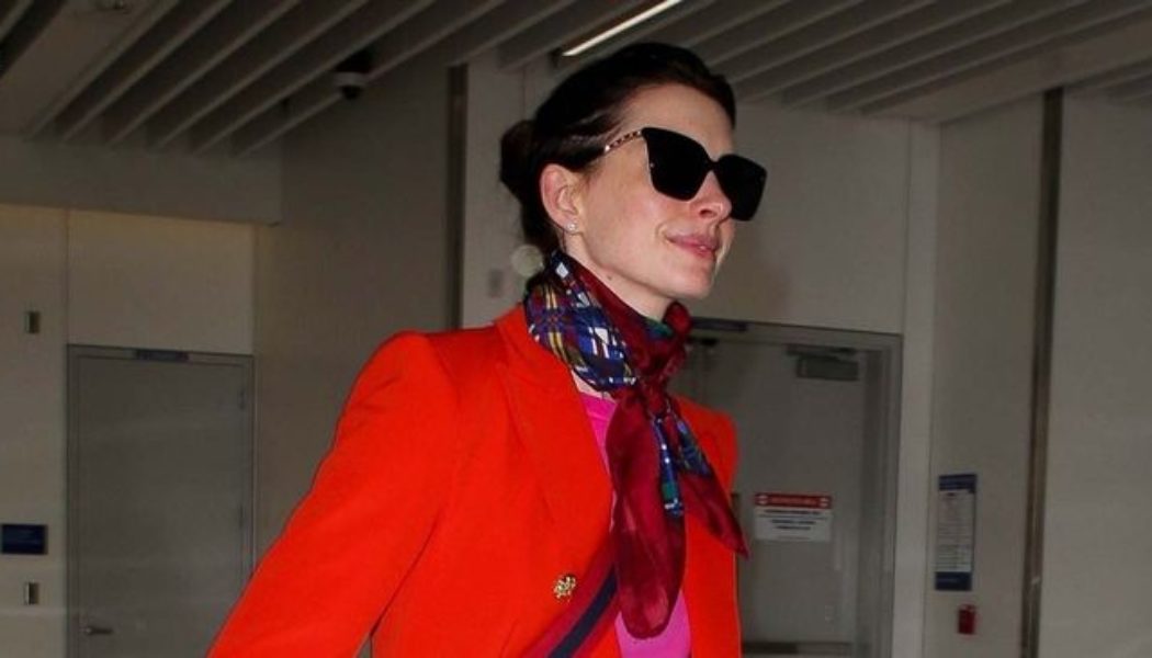 Anne Hathaway’s Airport Outfit Includes Puddle Pants and a Very ’90s Shoe Trend