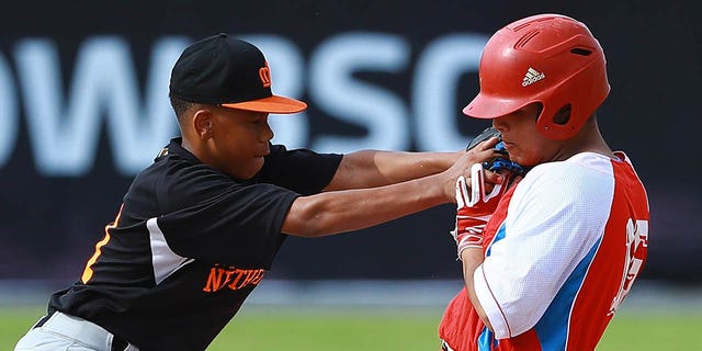 Jurrangelo Cijntje, #21 of Netherlands, tagged out Omar Riesgo, #26 of Cuba, during the WBSC U-15 World Cup Group B match between the Netherlands and Cuba at Estadio Rico Cedeno on Aug. 10, 2018 in Chitre, Panama. 