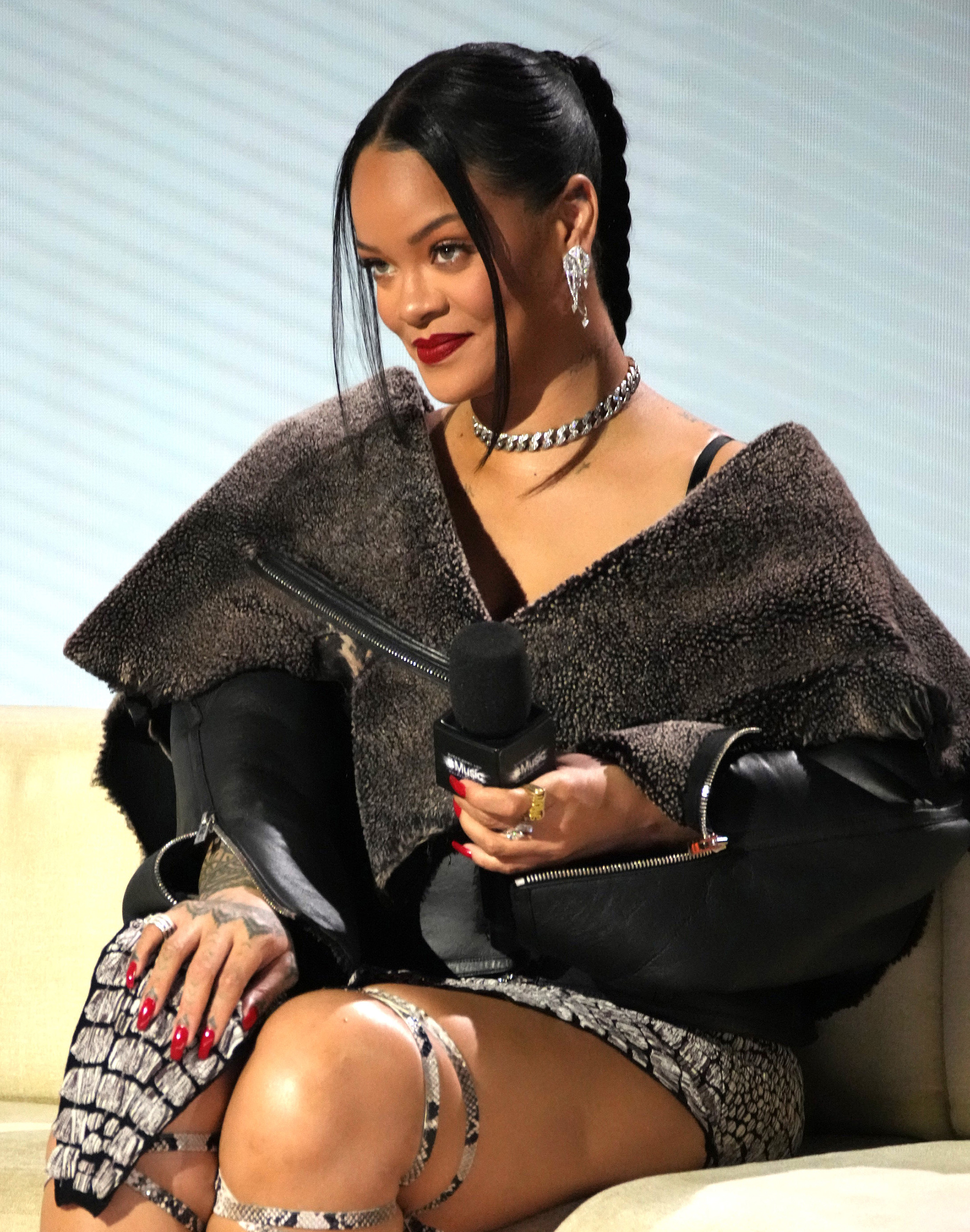 Rihanna sits in oversize jacket and skirt