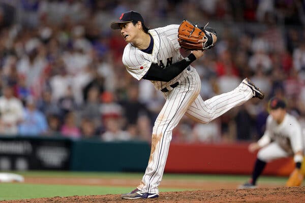 Shohei Ohtani, wearing the white uniform of Japan, follows through on a pitch.
