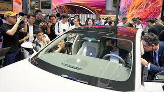 Besucher der Auto Shangai fotografieren Xiaomi-Gründer Lei Jun (am Steuer). Der CEO des Elektronikkonzerns hat in China Popstar-Status. Auf E-Autos seines Unternehmens muss die Branche allerdings noch warten. (Bild: picture alliance / ASSOCIATED PRESS)