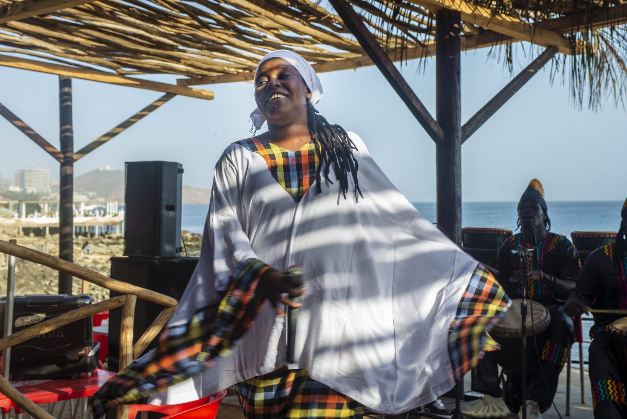 Woman, outside, drummers, ocean in the background