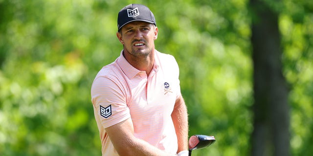 Bryson DeChambeau looks at shot