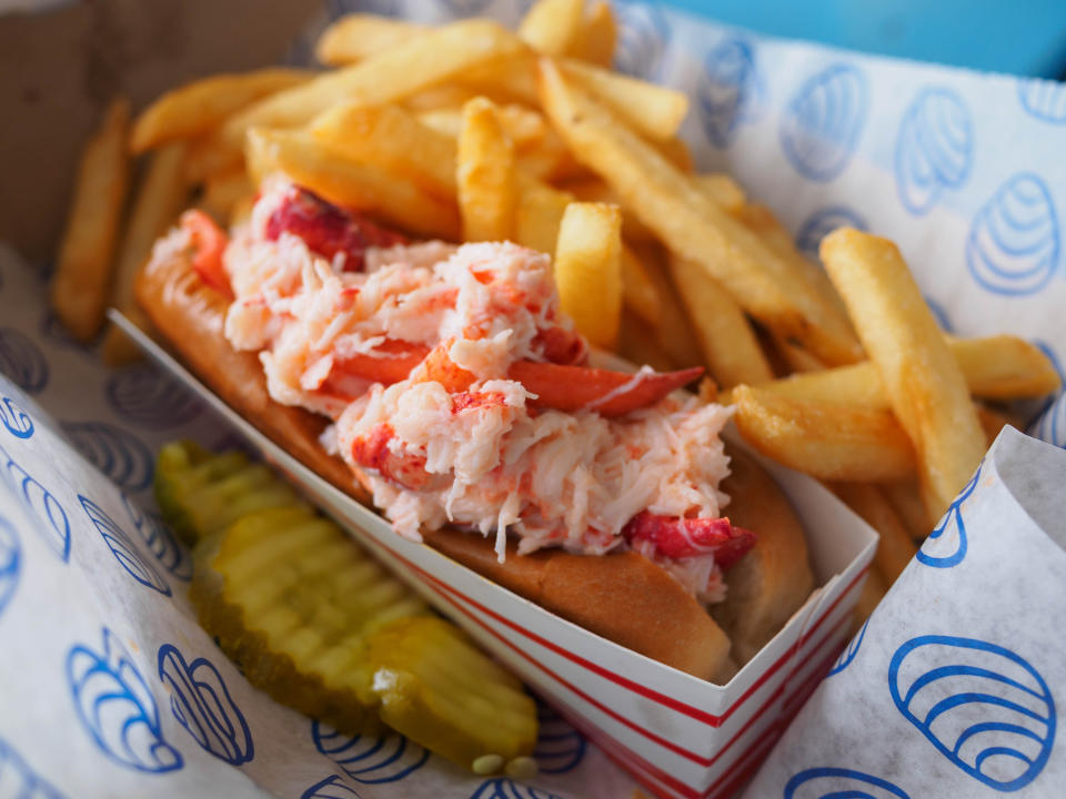 lobster roll served with pickles and fries
