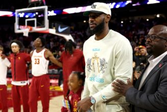 LeBron James faces scrutiny for entering USC arena while national anthem plays, sitting down as song plays
