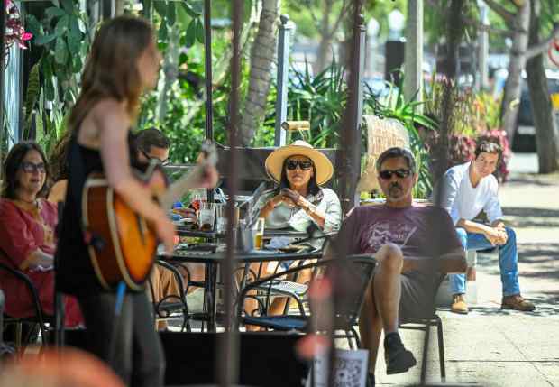 Visitors to Les Amis listen to Ren perform during Day...