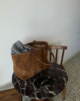 Influencer wears a brown suede bag.