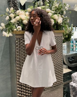 Emmanuelle Koffi photo in front of flowers wearing a white dress