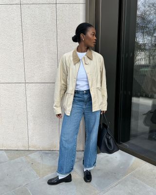 A fashion person wearing a barn jacket and jeans.
