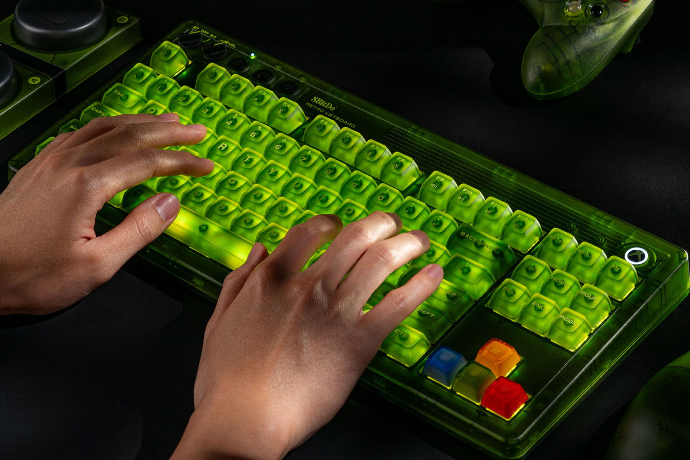 A pair of hands typing on the 8BitDo Retro 87 Mechanical Keyboard - Xbox Edition while it’s glowing green.