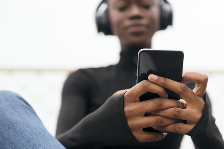 young female in headphones listening song on phone