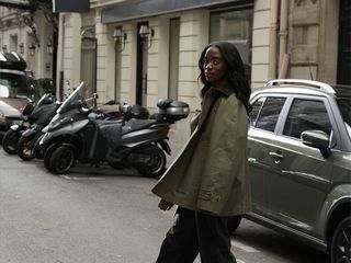 liv wears a green barn jacket, black trousers, and brown shoes and bag