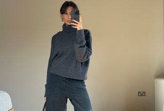 Marianne Smyth in a grey sweater, cargo pants, and green sneakers.