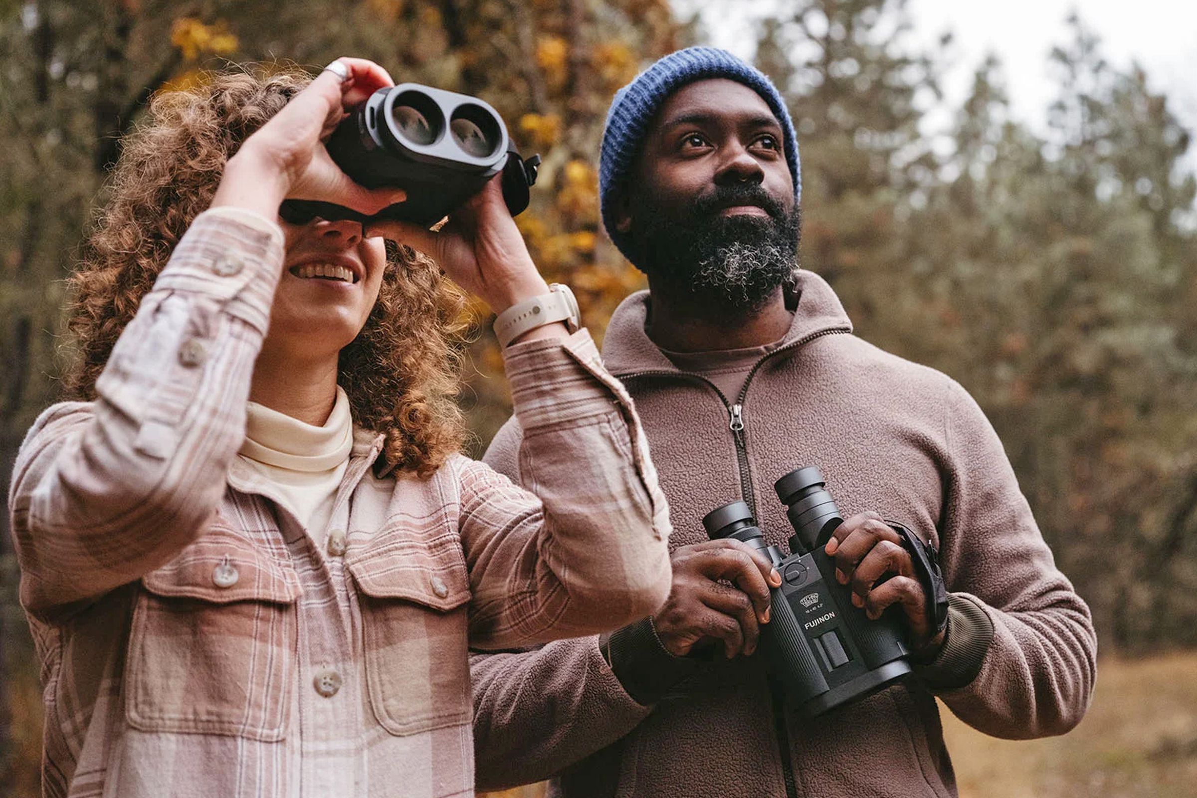 Two people using Fujifilm’s new stabilized binoculars.