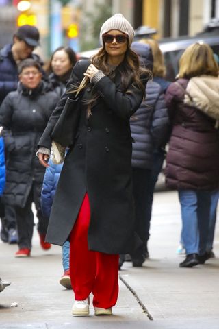Katie Holmes wears red trousers.