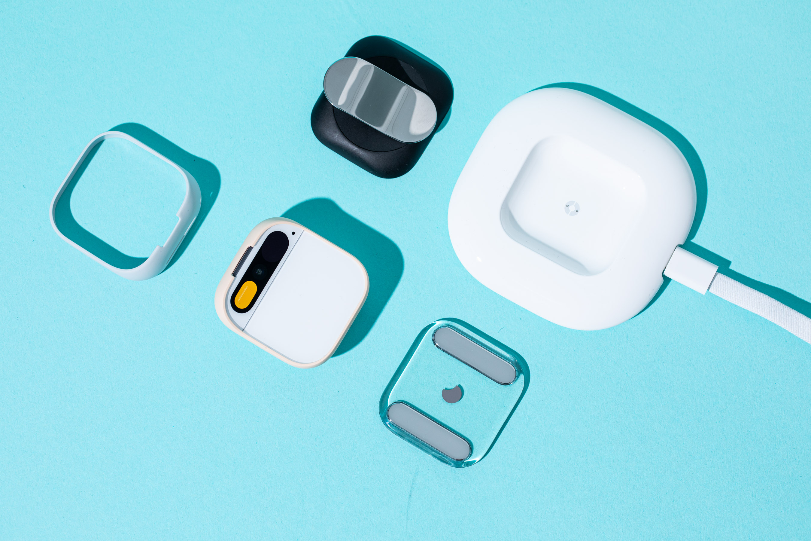 A photo of the Humane AI Pin with several accessories.