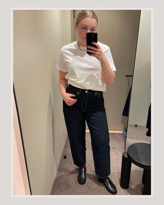 Woman wears white t-shirt and blue jeans and loafers