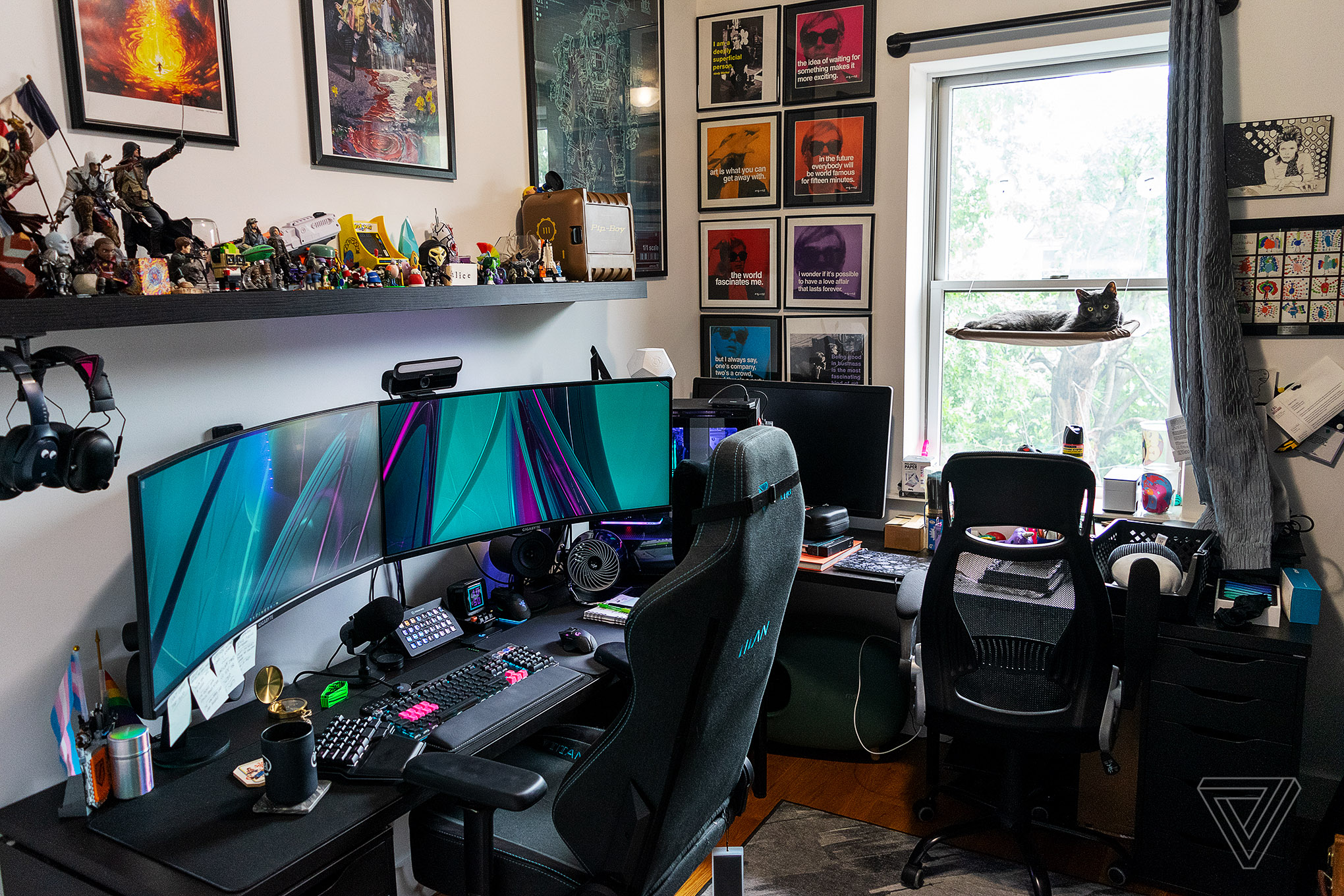 Room with desks, screens, a shelf with toys and a cat.