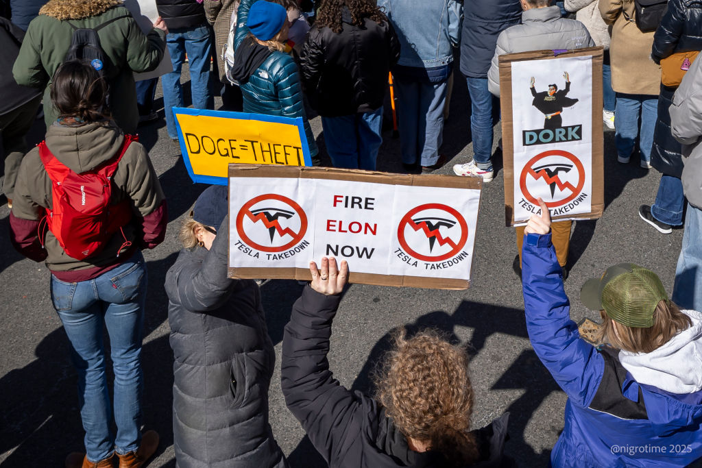 A protestor outside a Tesla showroom in Manhattan holds a...