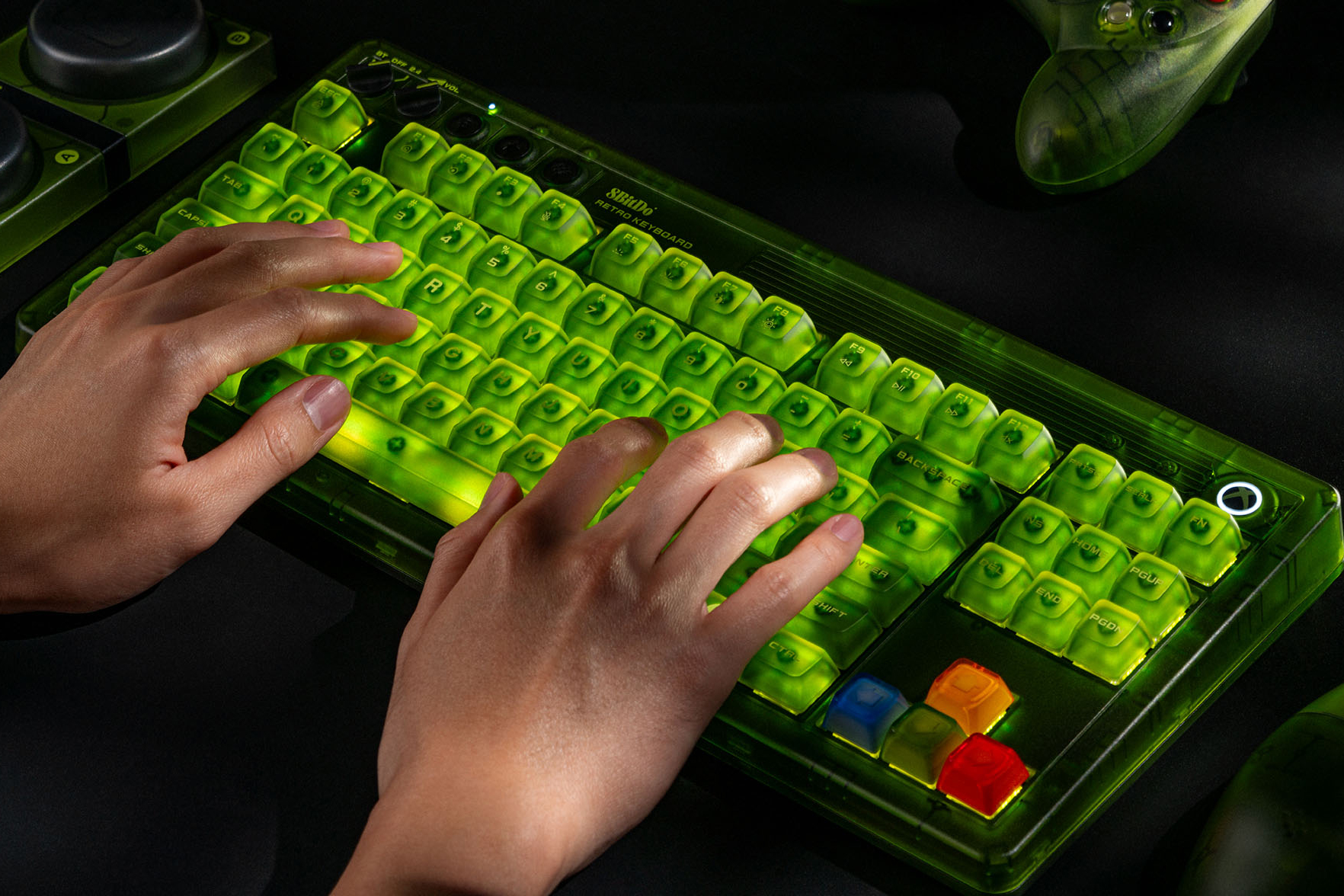 A pair of hands typing on the 8BitDo Retro 87 Mechanical Keyboard - Xbox Edition while it’s glowing green.