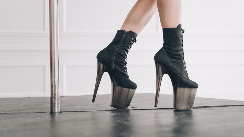 Girl's legs in high heels - strips in a light room