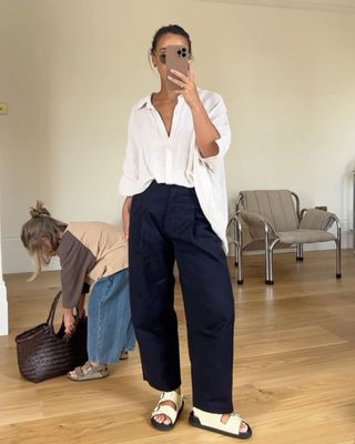 Influencer wears navy trousers.