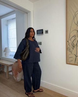 Influencer wears navy trousers.