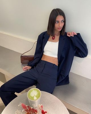 Influencer wears navy trousers.