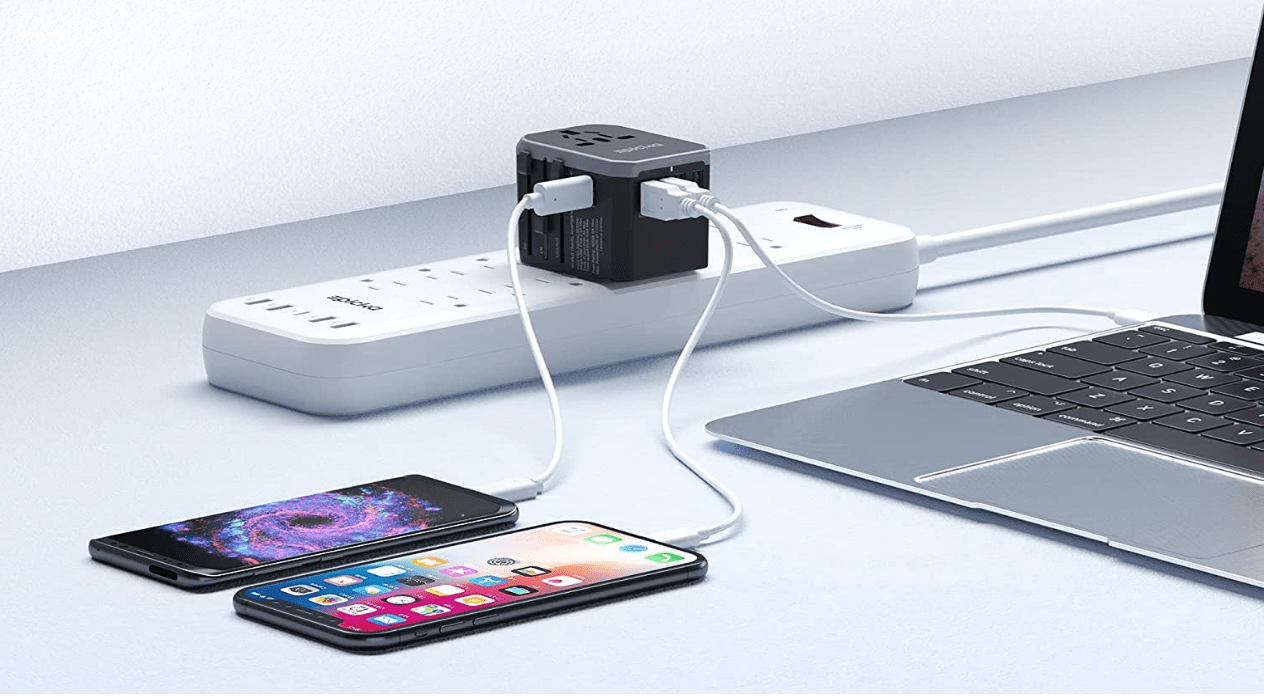 Travel adaptor on power strip connected to phones and laptop.