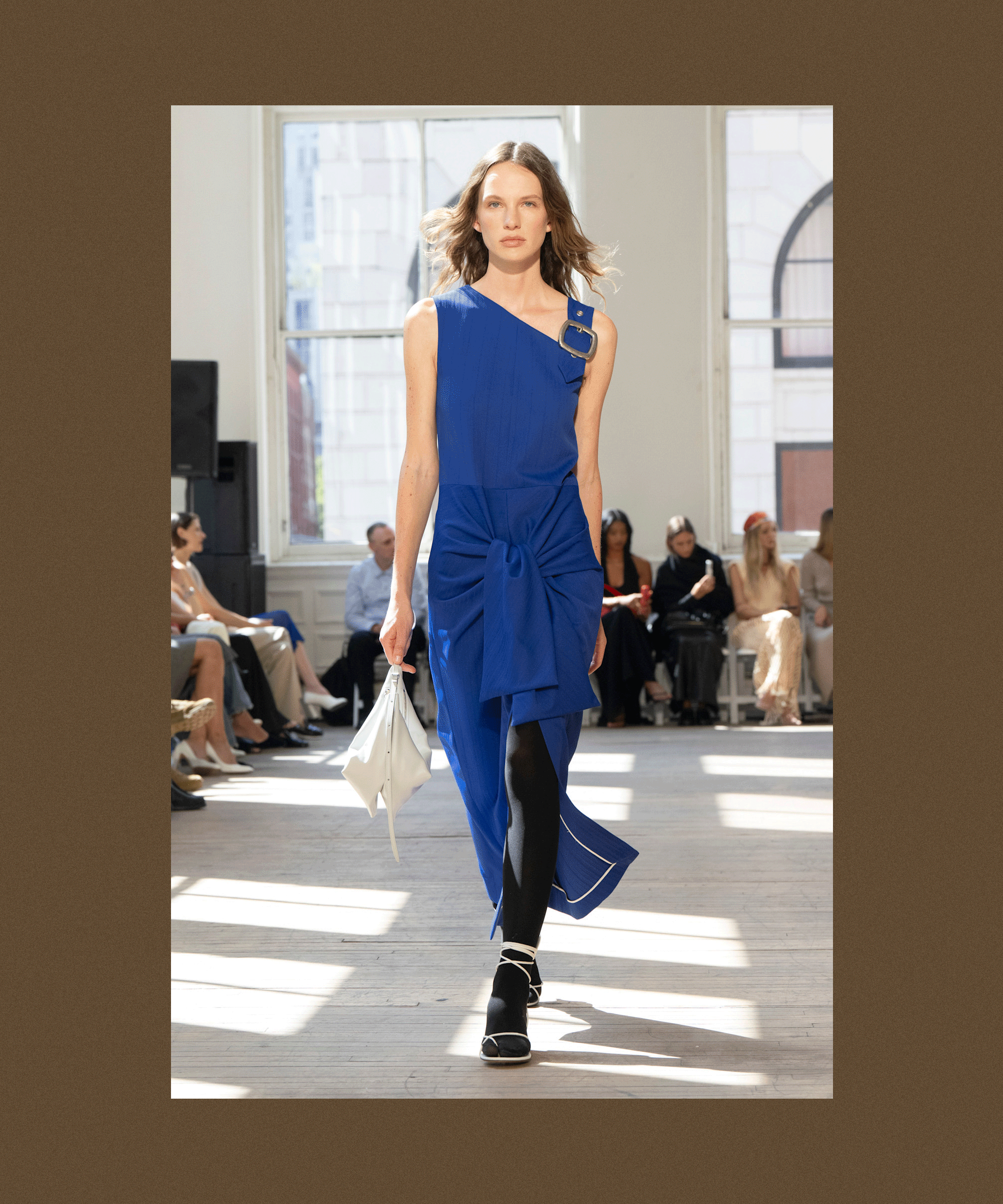 A brown backdrop with flashing images from the S/S 25 Proenza Schouler show, showcasing tights being styled with sandals and dresses for spring.