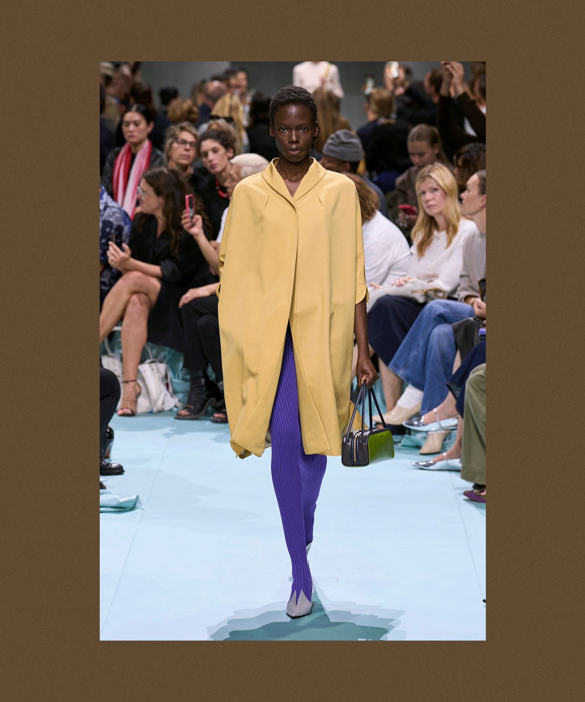 A brown backdrop with flashing images from the S/S 25 Prada show, showcasing sweater tights being styled with heels for spring.