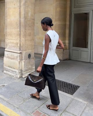 Syvlie wears a white top and black crop pants.