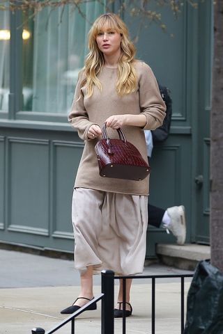 Jennifer Lawrence wearing a tan sweater and The Row Lady Bag