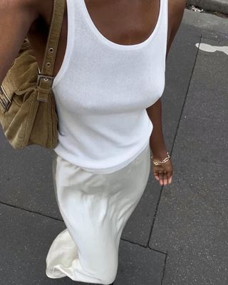 Sylvie Mus wearing a white tank top with a white slip skirt.