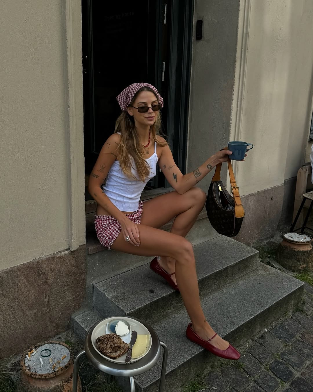 Woman wearing white tank and bloomer shorts with ballet flats in a summer 2025 outfit.