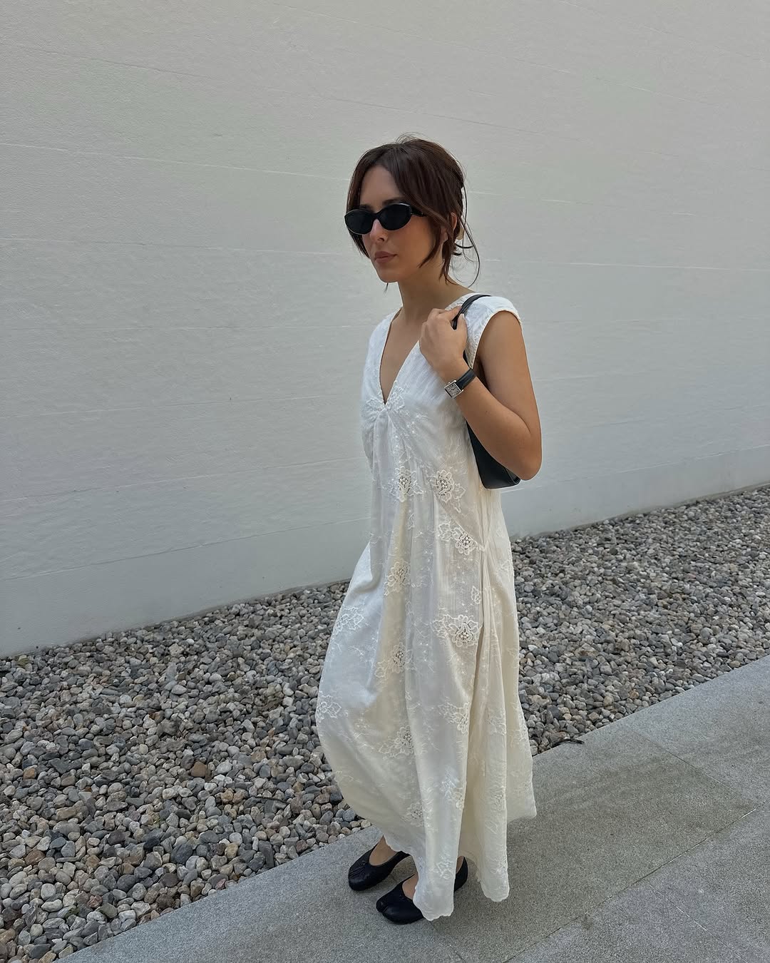 Woman wearing white maxi dress with ballet flats in a summer 2025 outfit.