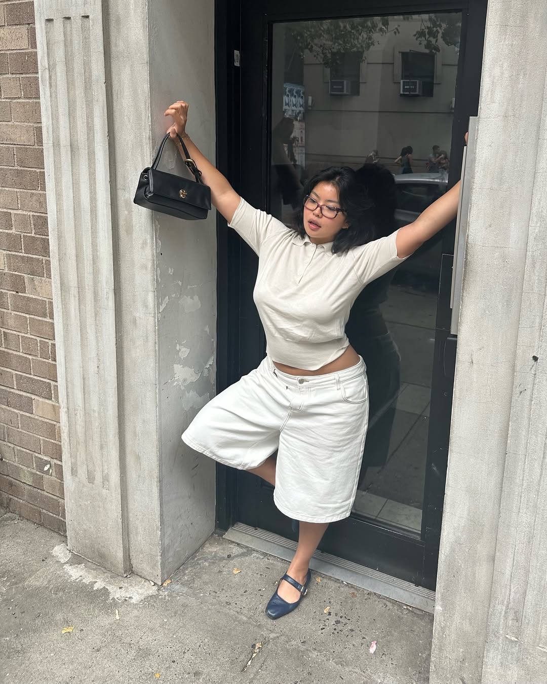 Woman wearing white t-shirt and white jorts with ballet flats in a summer 2025 outfit.