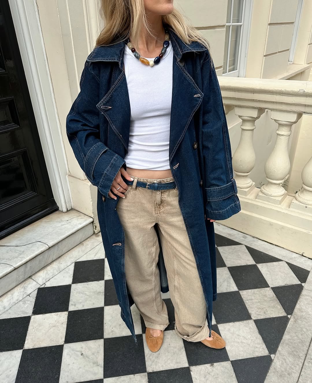 Woman wearing denim trench coat with loose jeans and ballet flats in a summer 2025 outfit.
