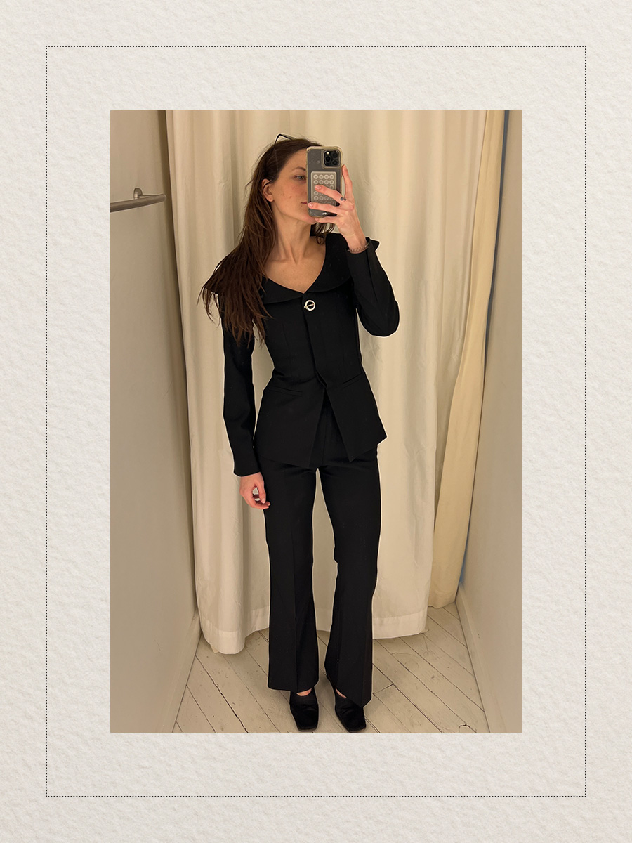 Eliza Huber at the new Aligne pop-up store in New York City's SoHo district trying on a black blazer and matching flare trousers.