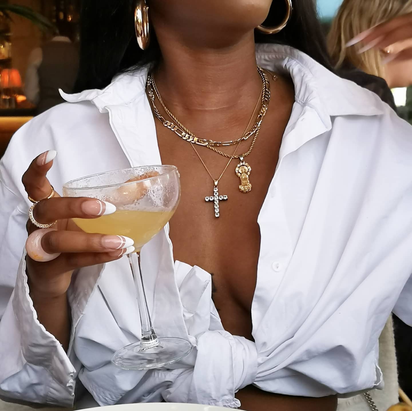 aureliee wears a button down shirt tied up and mixed metal necklace stack