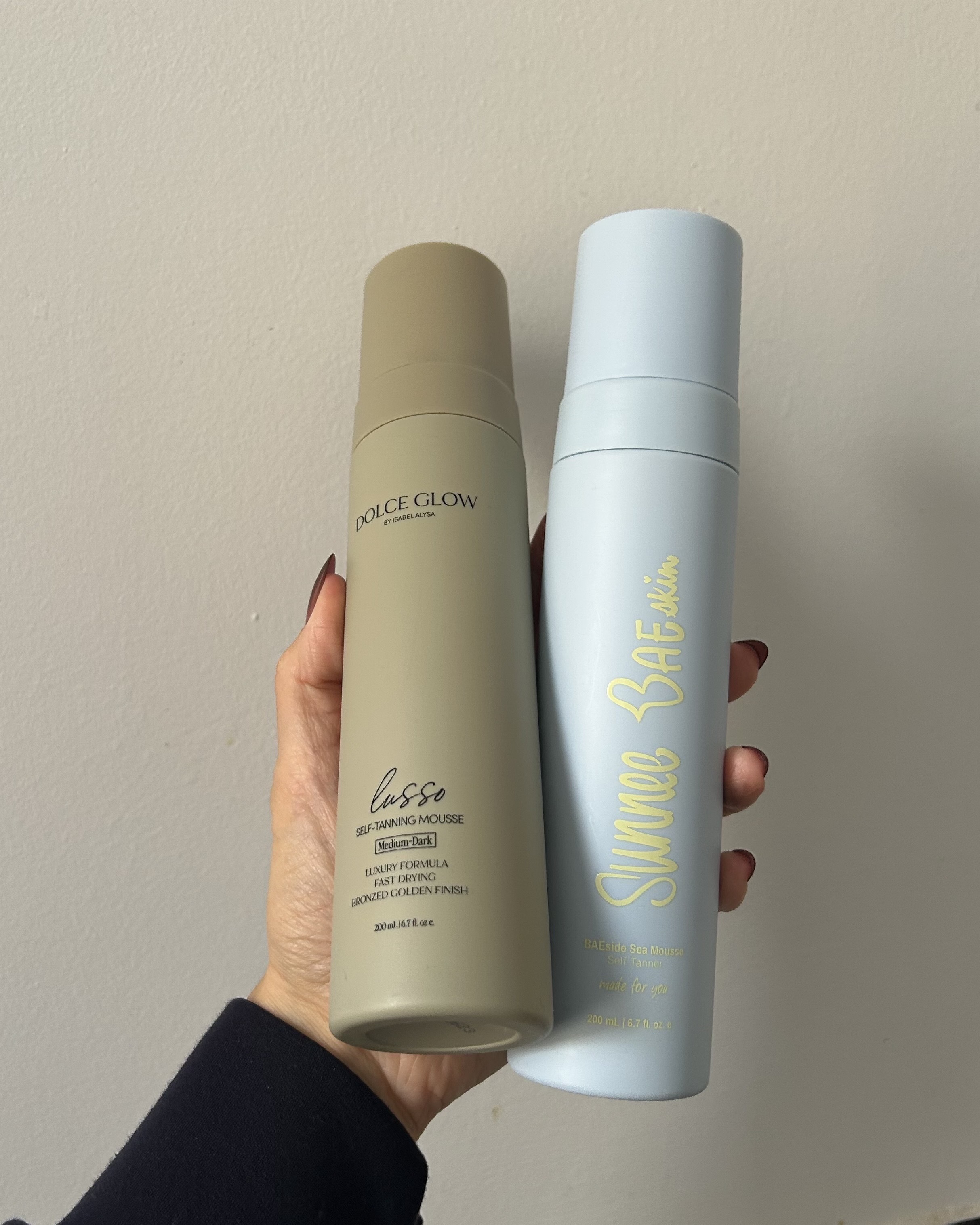 Alyssa Brascia holding self-tanning mousses.