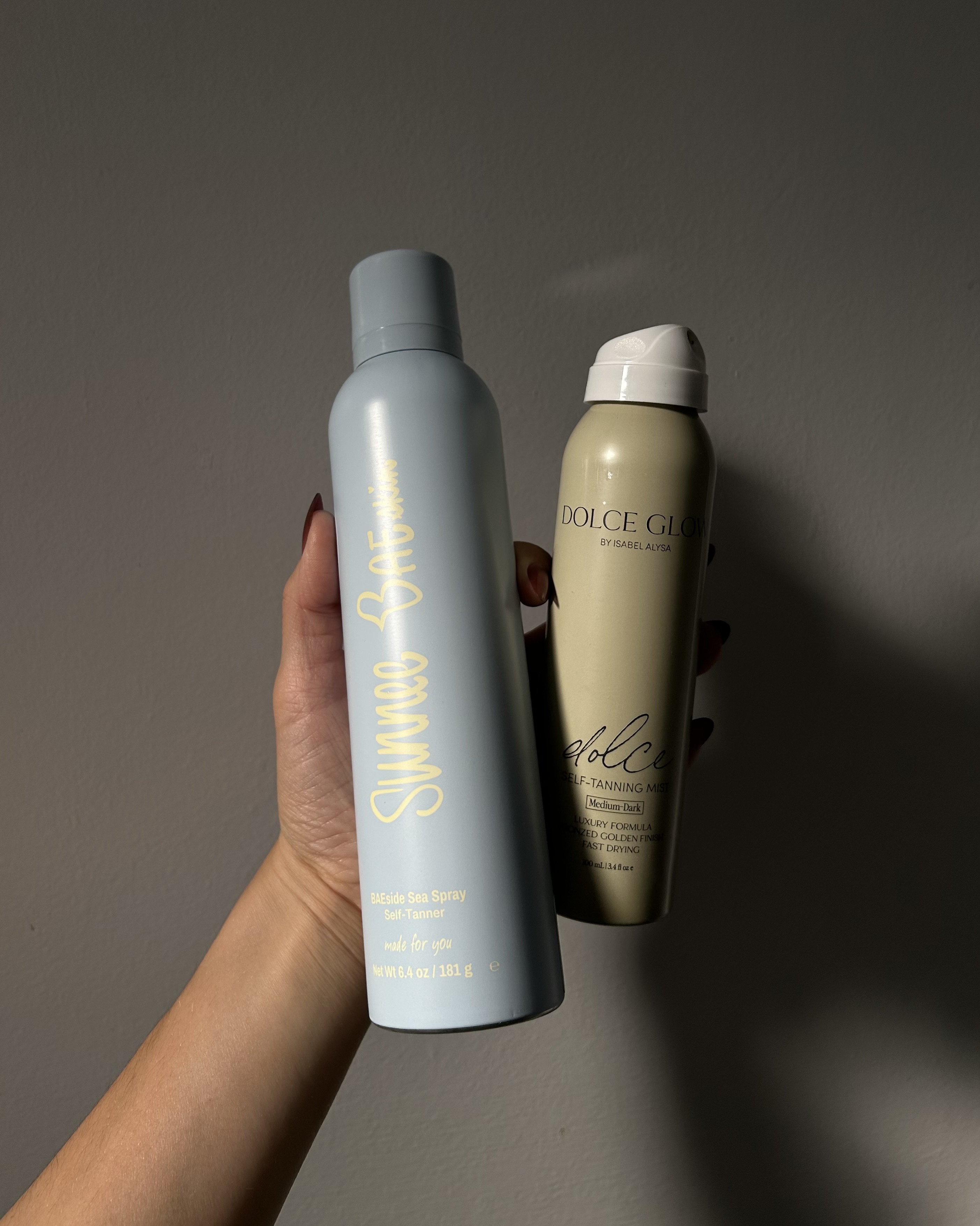 Alyssa Brascia holding self-tan sprays.