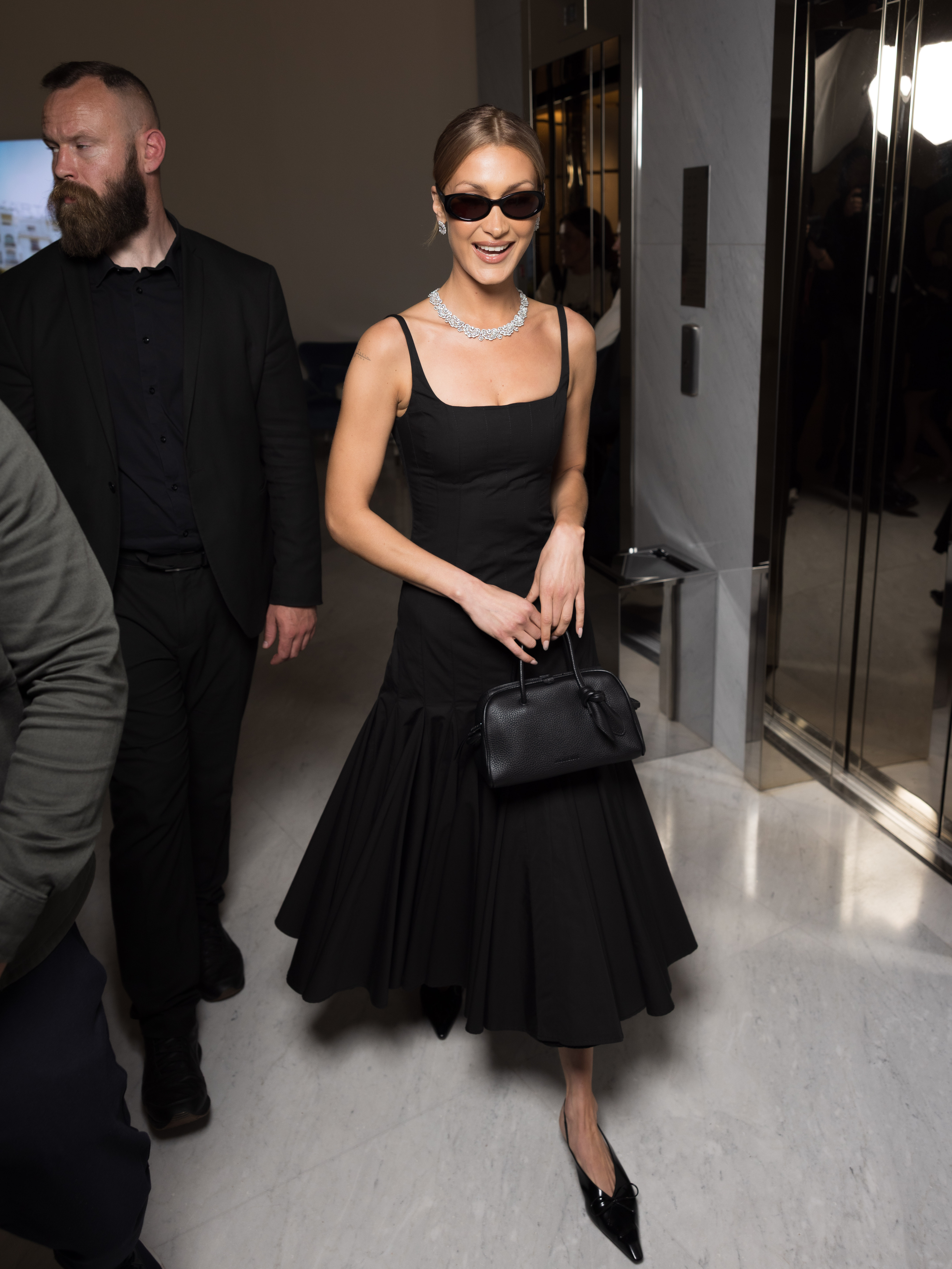 Bella Hadid wears a black drop waist dress.