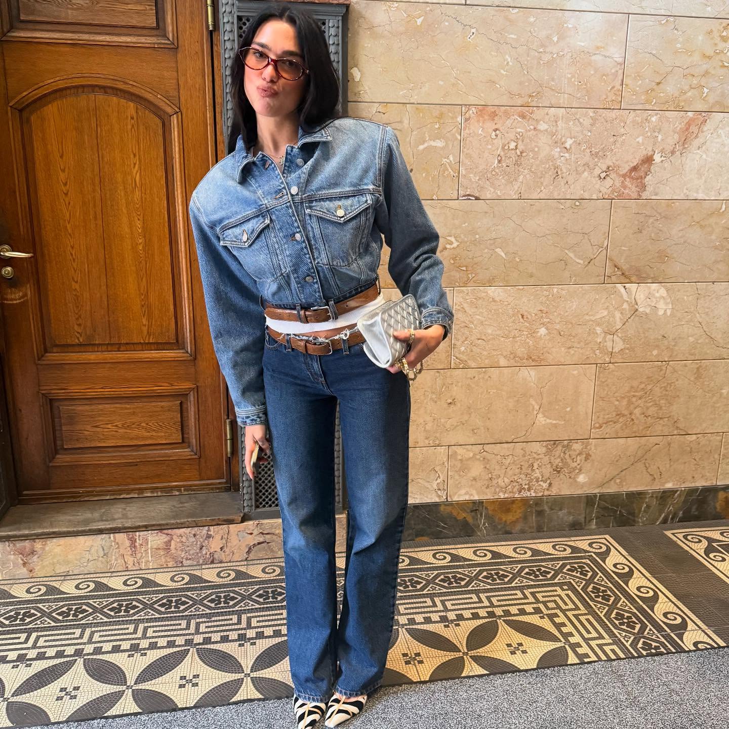 Dua Lipa wearing a denim-on-denim outfit and zebra-print heels