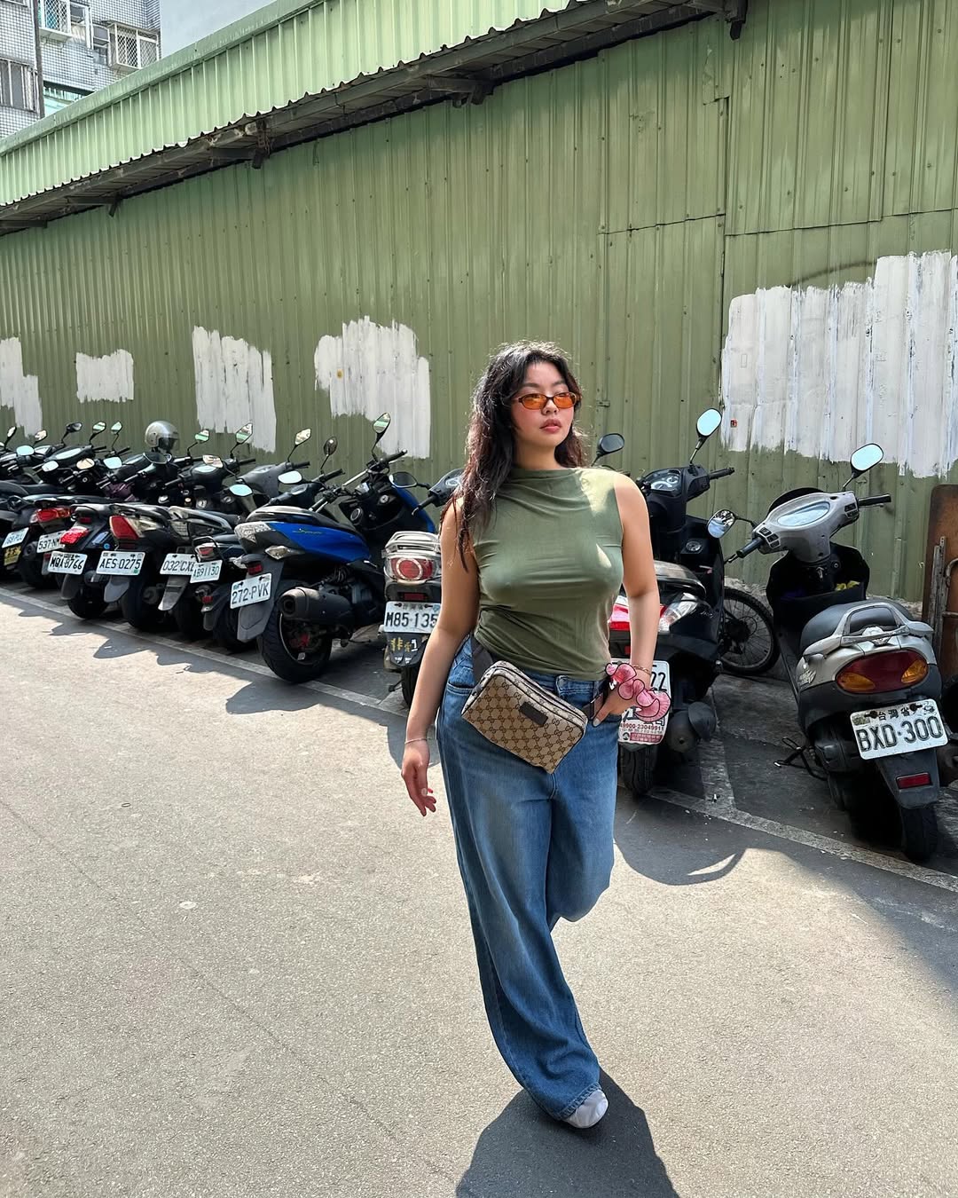 woman wearing green top with loose jeans summer 2025 outfit