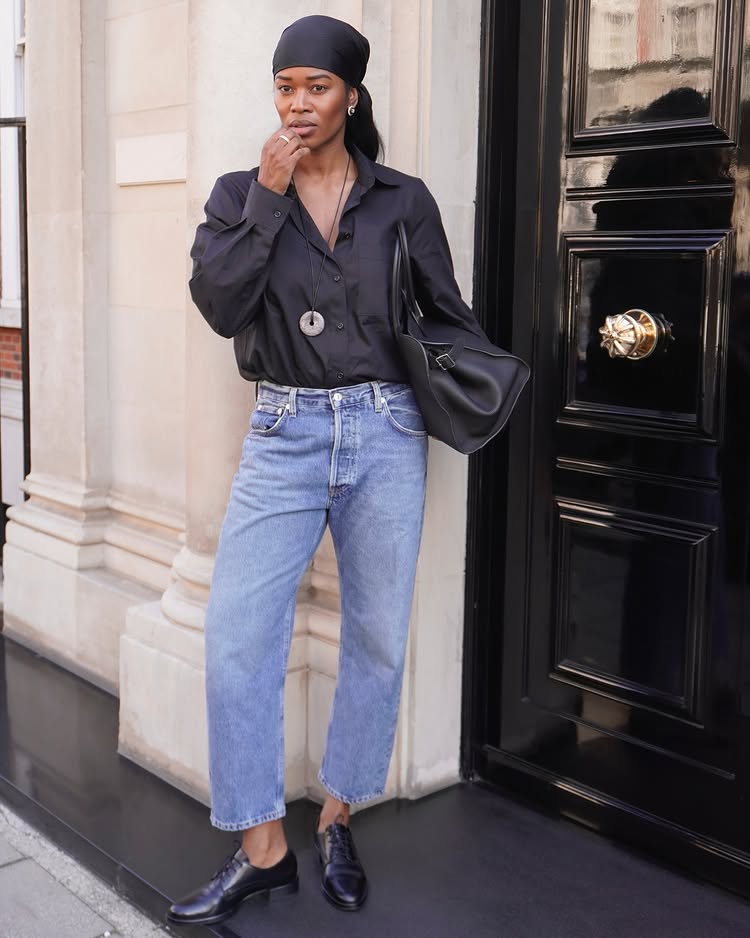 Stockholm Fashion Trends 2025: @nlmarilyn wears a black shirt, blue jeans and a long pendant necklace