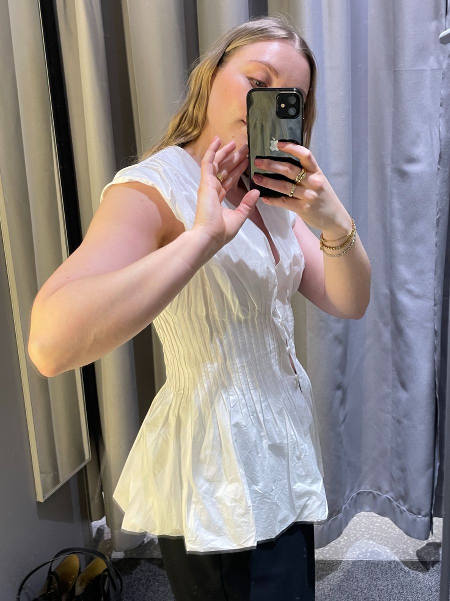 Woman wears white top and black trousers