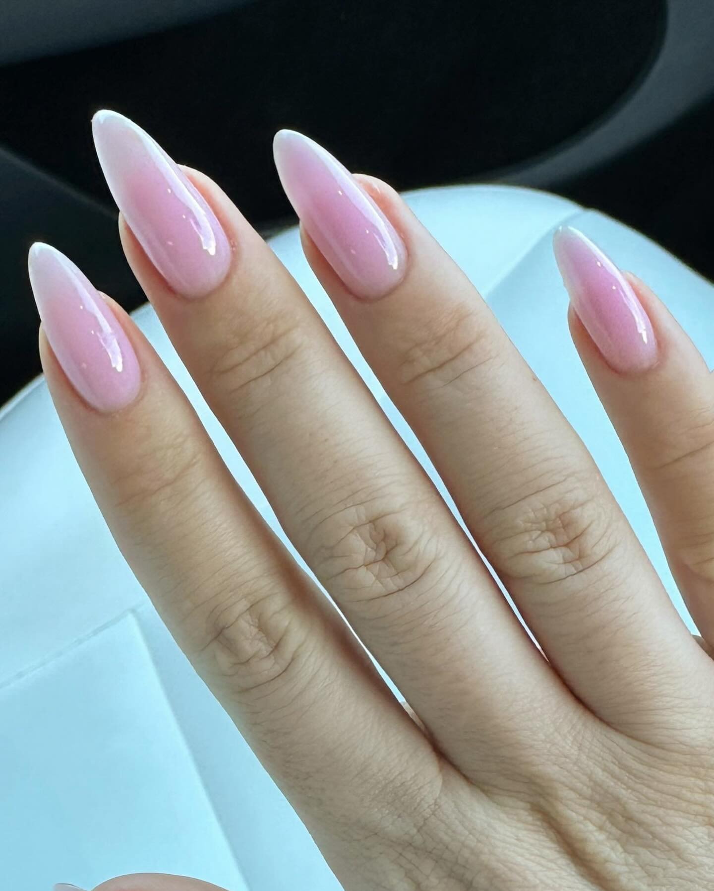 Woman's hands with a light gradient pink manicure.