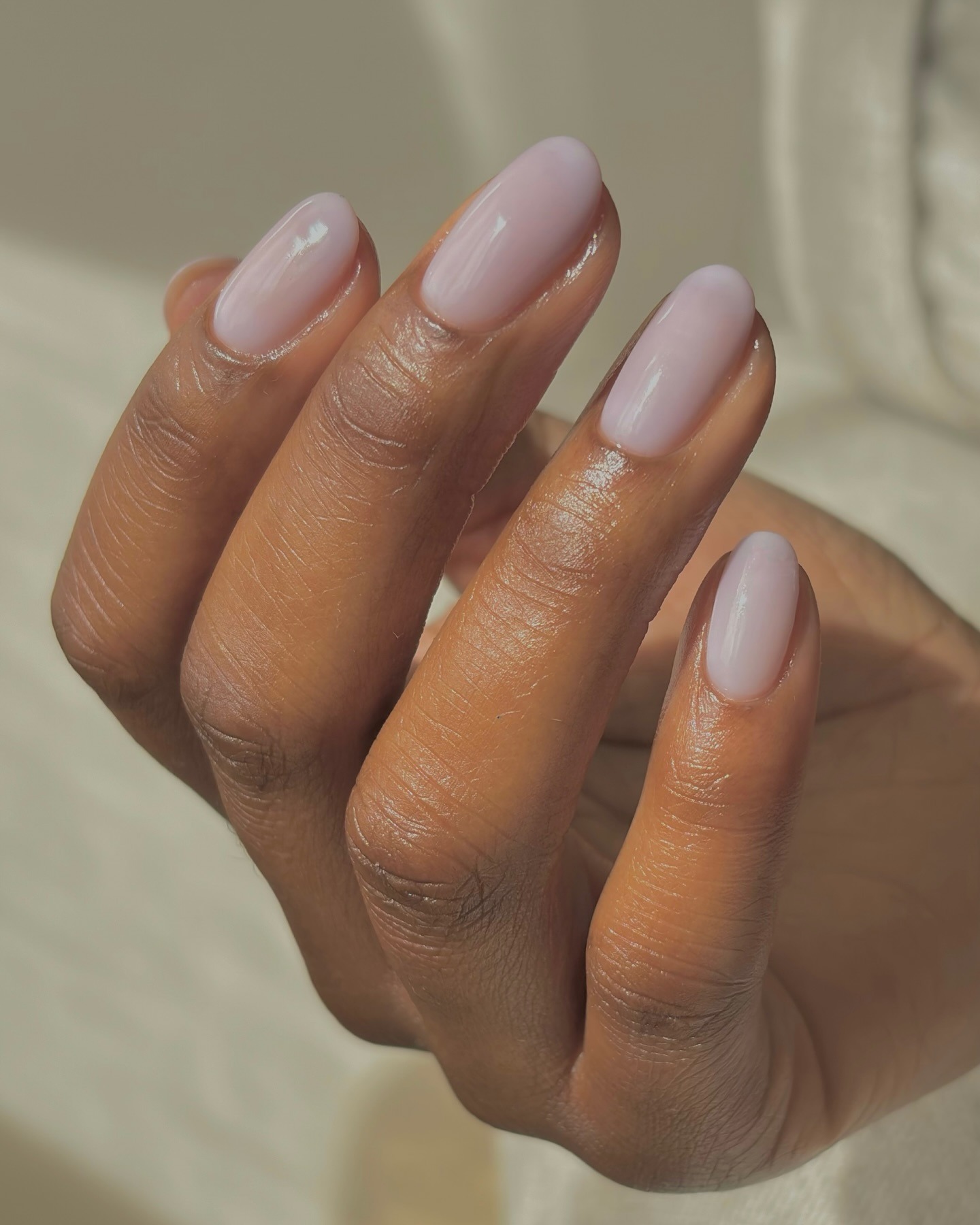 Woman's nails painted in a sheer syrup lavender by Julia Diogo.